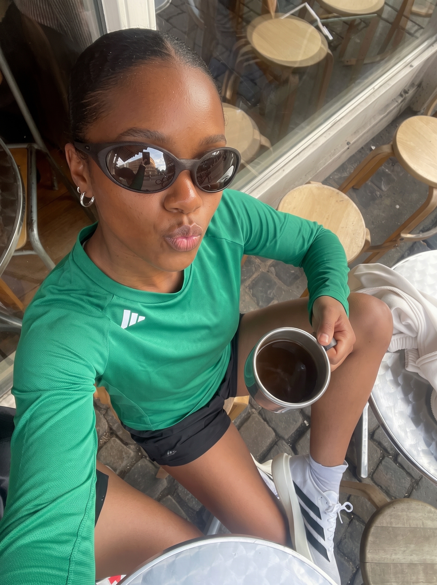 Woman in green activewear at an outdoor café terrace