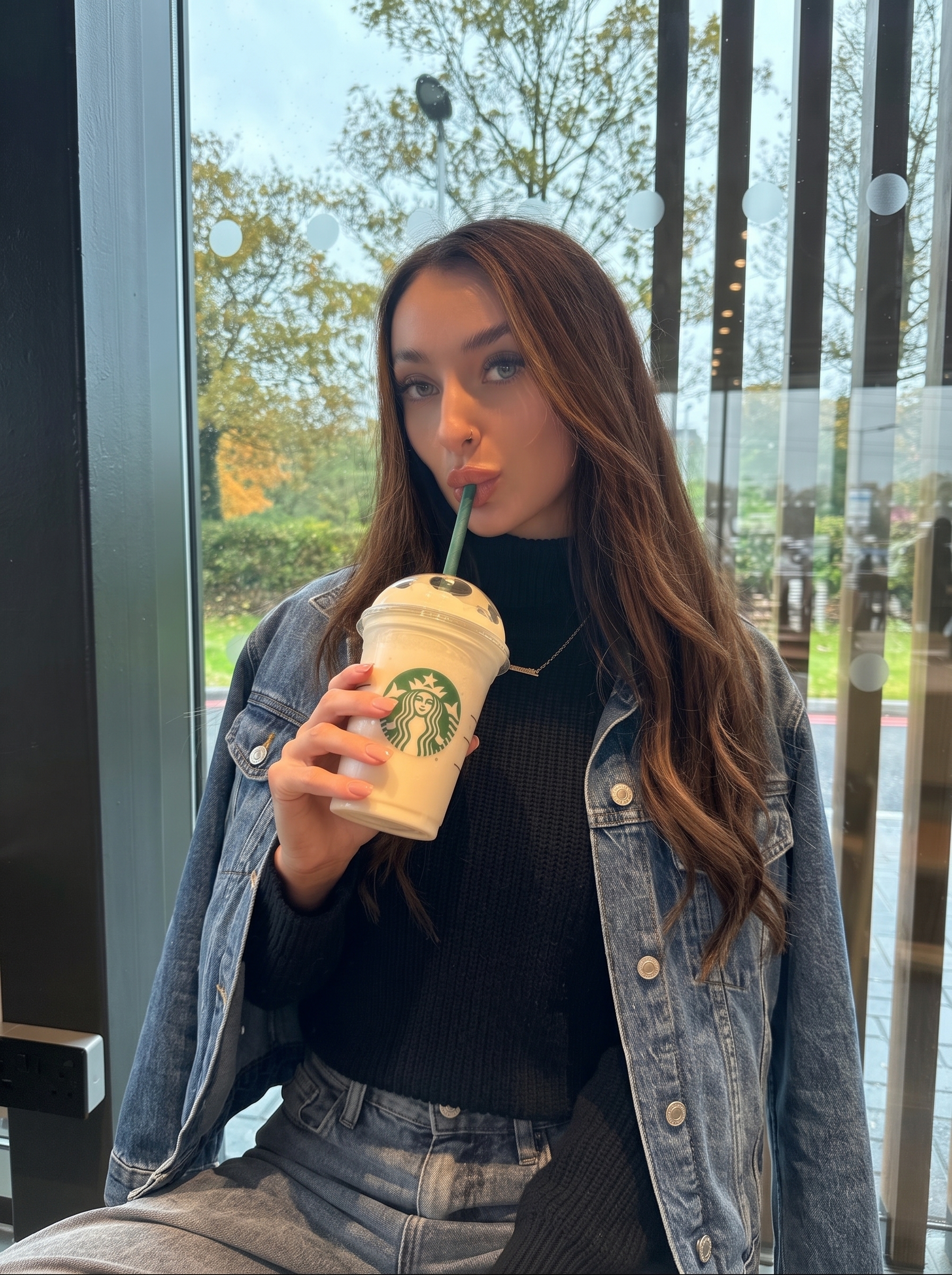 Woman at a café holding a frappuccino