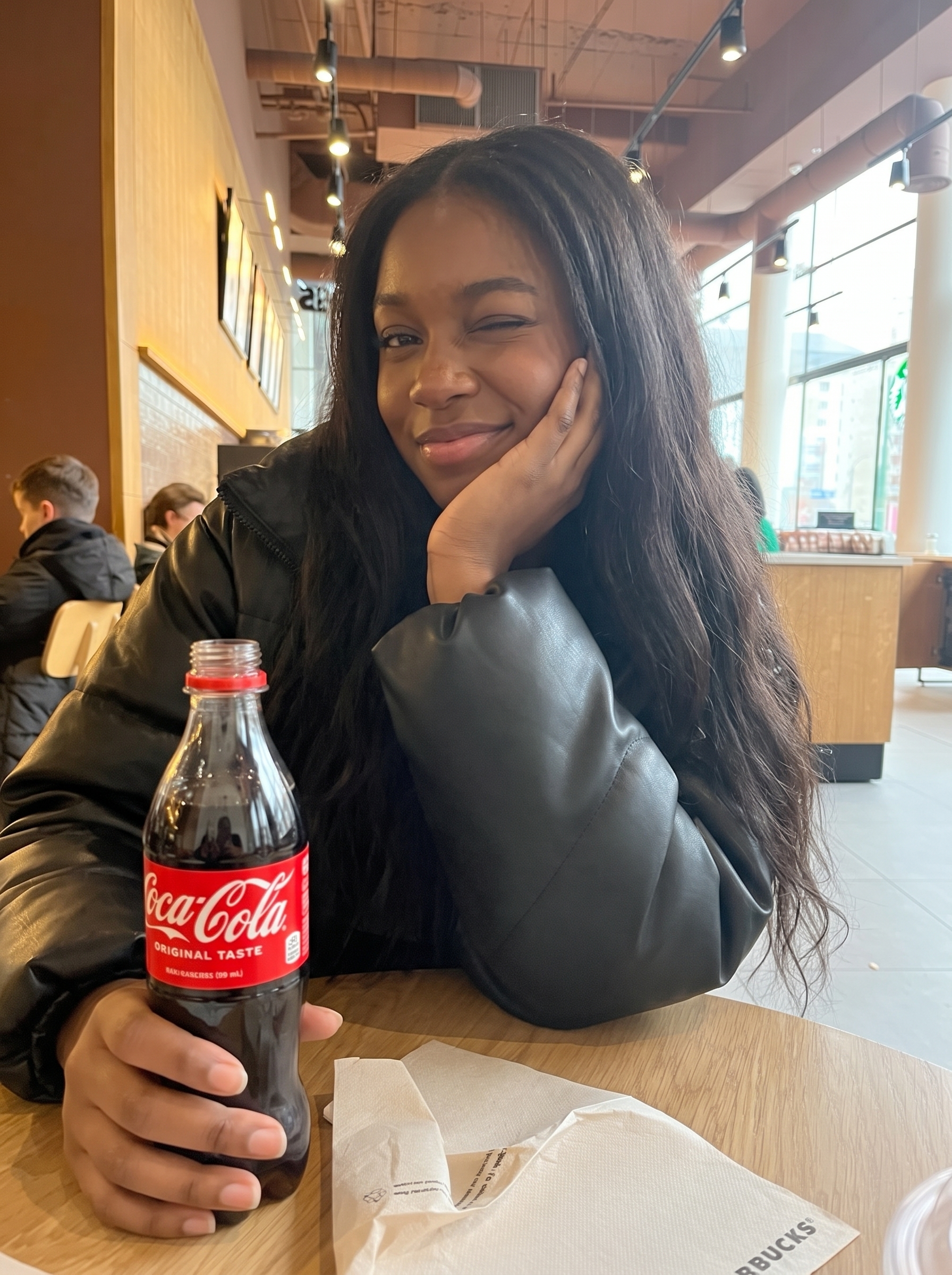 Young woman smiling with a Coca-Cola bottle
