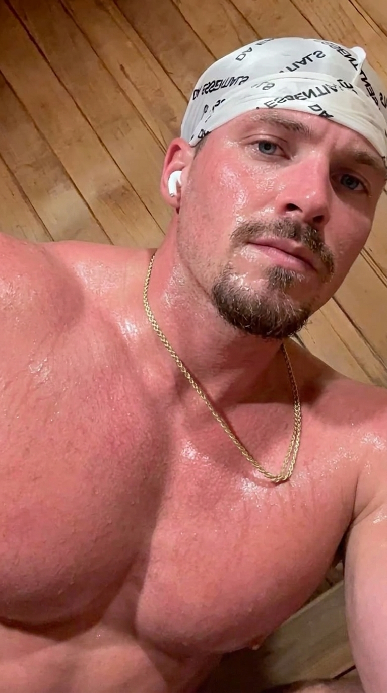 Athletic man taking a sweaty selfie in a sauna