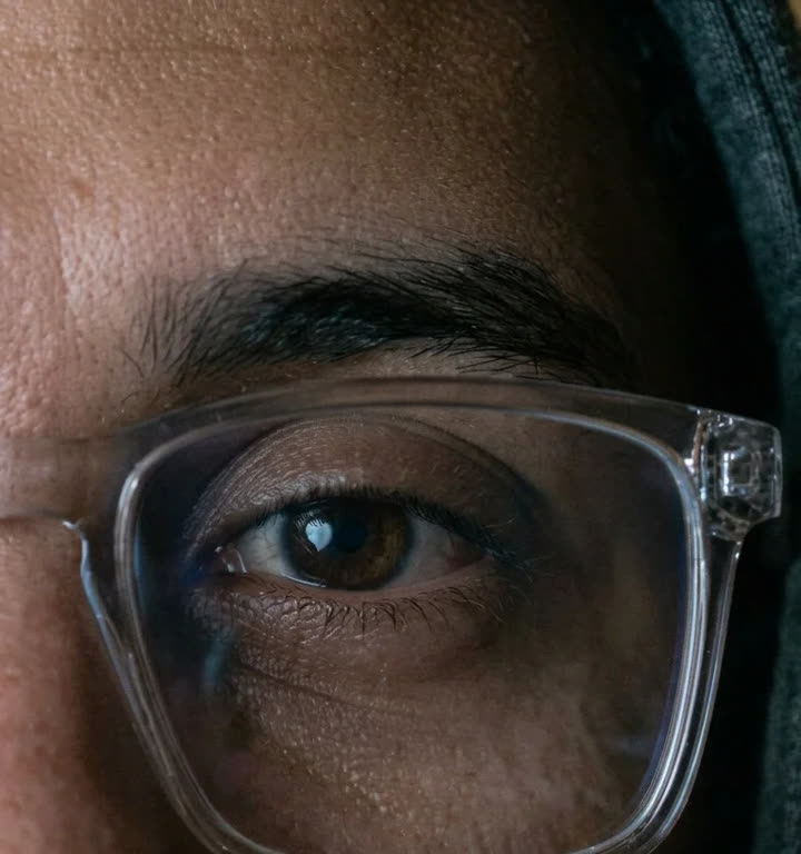 Extreme close-up of a human eye with a computer screen reflected in the iris.